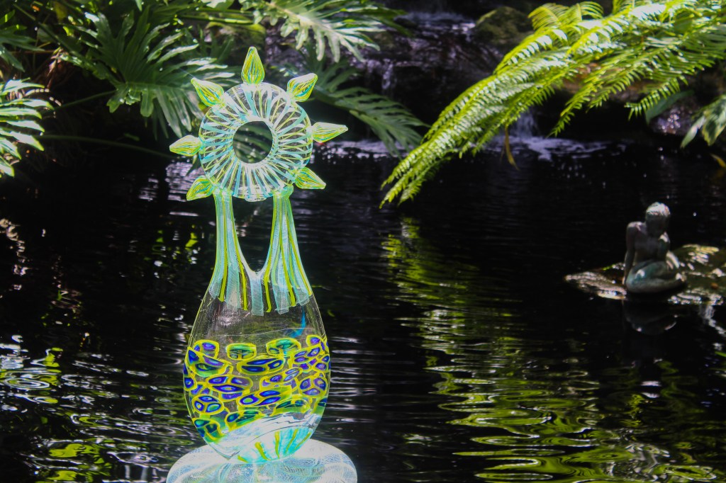 glass art piece in the middle of pond