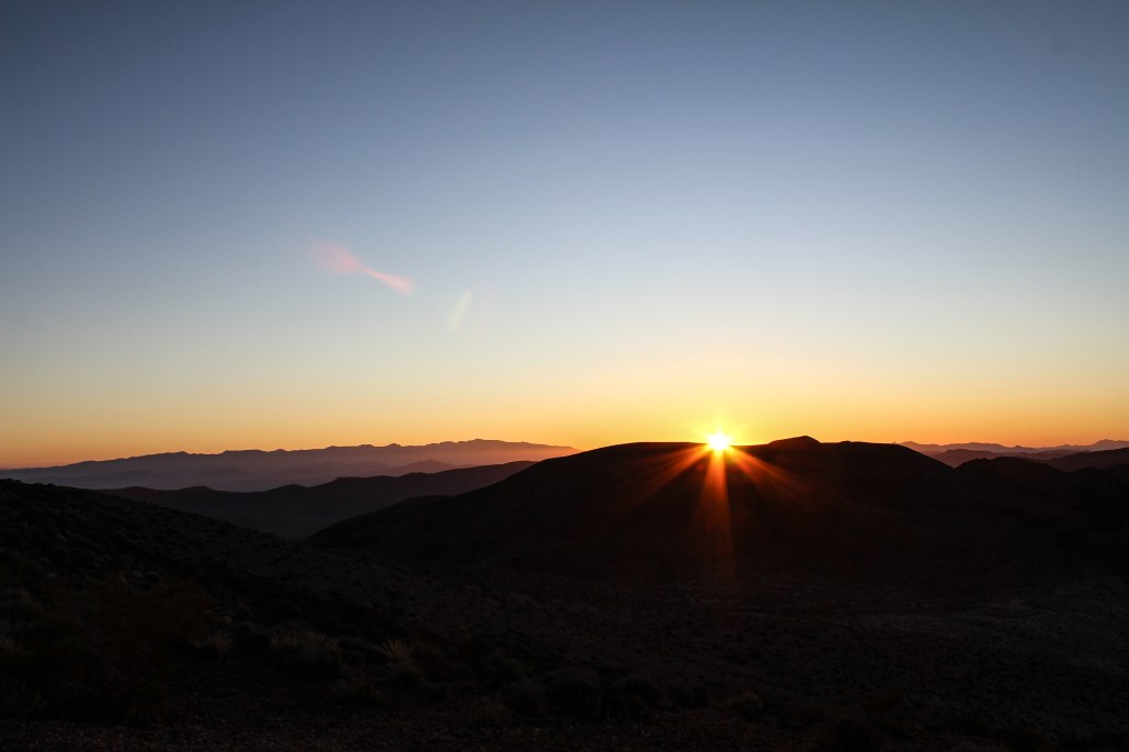 sun emerging from behind the mountains at Dante's View